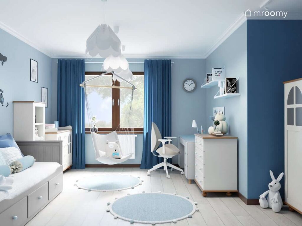 Pokój dla dziewczynki z niebieskimi ścianami i białym sufitem oraz wiszącym fotelem niebieskimi zasłonami i niebiesko szarymi dywanami