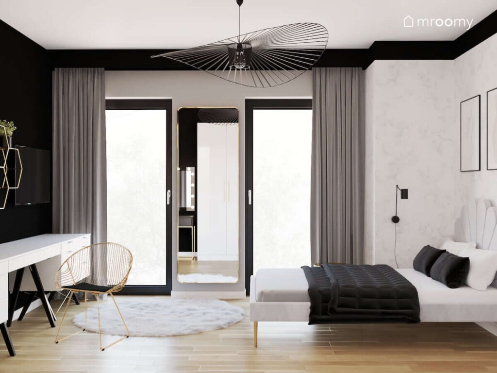 Monochromatyczny pokój dla nastolatki z tapicerowanym łóżkiem podłużnym lustrem dekoracyjną lampą sufitową oraz szarymi zasłonami i szarym dywanem