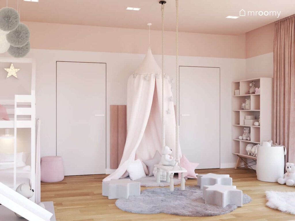 Miejsce do wypoczynku i zabawy z puszystymi dywanami pufkami w kształcie gwiazdek i pudroworóżowym baldachimem w biało różowym pokoju dla kilkuletniej dziewczynki