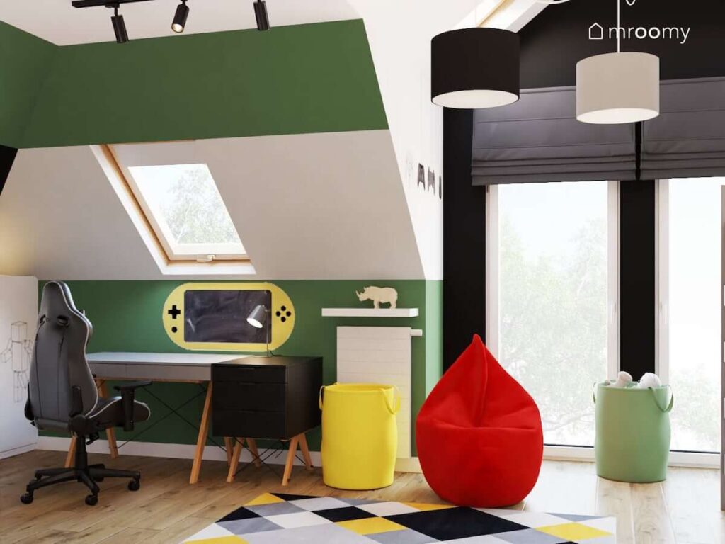 Poddaszowy pokój w stonowanych kolorach dla fana gier komputerowych z biurkiem i kontenerkiem na drewnianych nogach kolorowymi koszami na zabawki oraz czerwoną pufą sako