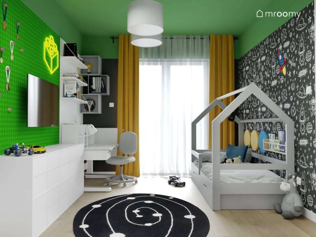 Soczyście zielony pokój dla chłopca z łóżkiem domkiem białymi meblami dywanem przedstawiającym drogę mleczną i żółtymi zasłonami