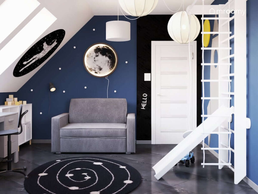 Kosmiczny poddaszowy pokój dla chłopca z rozkładaną sofą drabinką gimnastyczną ze zjeżdżalnią i kinkietem w kształcie księżyca