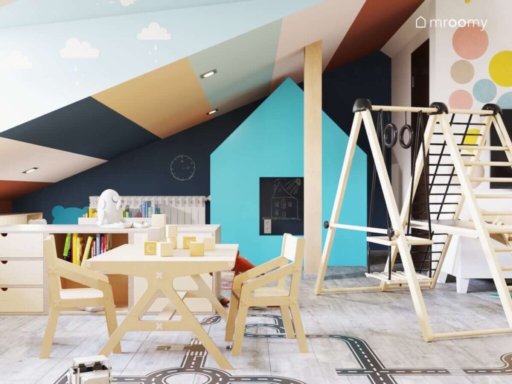 Kolorowy poddaszowy pokój dla dwóch dziewczynek z drewnianymi meblami oraz zestawem gimnastycznym