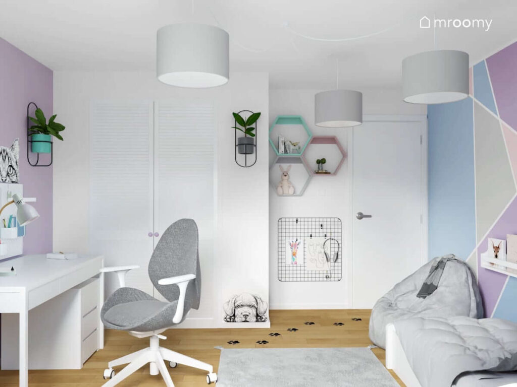 Jasny pokój dla dziewczynki z białym biurkiem z szarym krzesłem białą szafą organizerem ściennym kwietnikiem i kolorowymi półkami w kształcie heksagonów