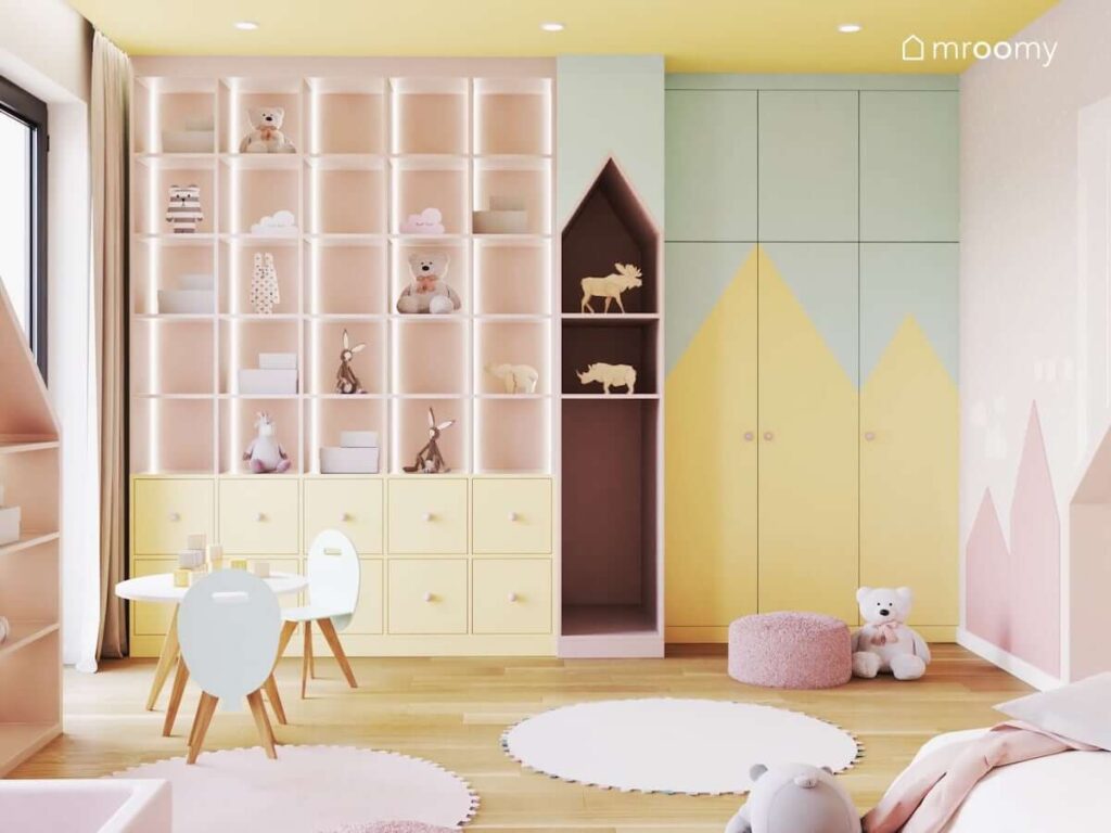 Oryginalna kolorowa zabudowa meblowa a także szafa pomalowana w trójkątny wzór w pokoju dla małej dziewczynki