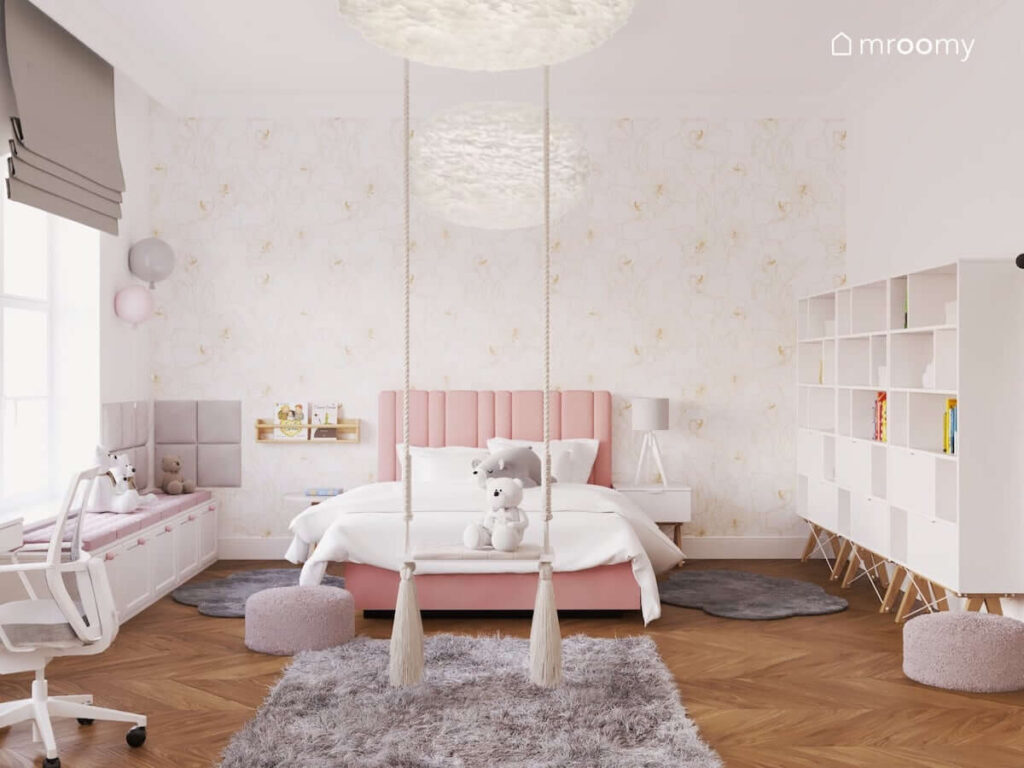 Jasny przestronny pokój dla dziewczynki w wieku szkolnym z różowym łóżkiem tapicerowanym szarymi dywanami i huśtawką pokojową