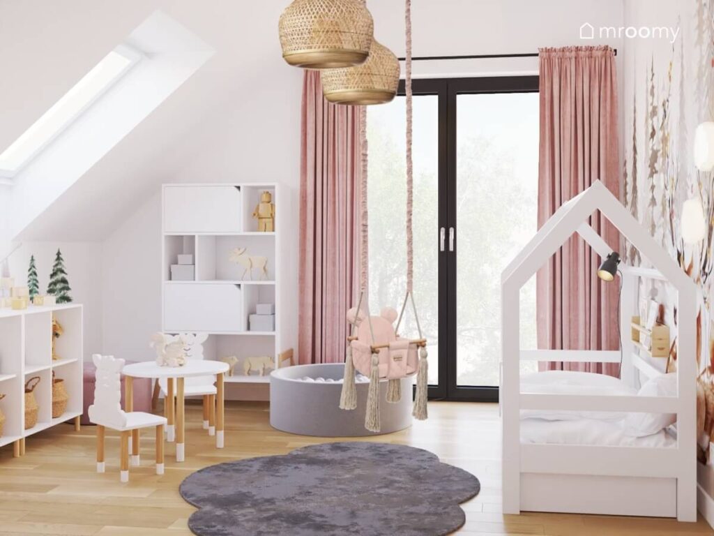 Jasny pokój dla małej dziewczynki a w nim łóżko domek wisząca huśtawka basen z kulkami stolik z krzesełkami z oparciami w kształcie alpak oraz szary dywanik w kształcie chmurki