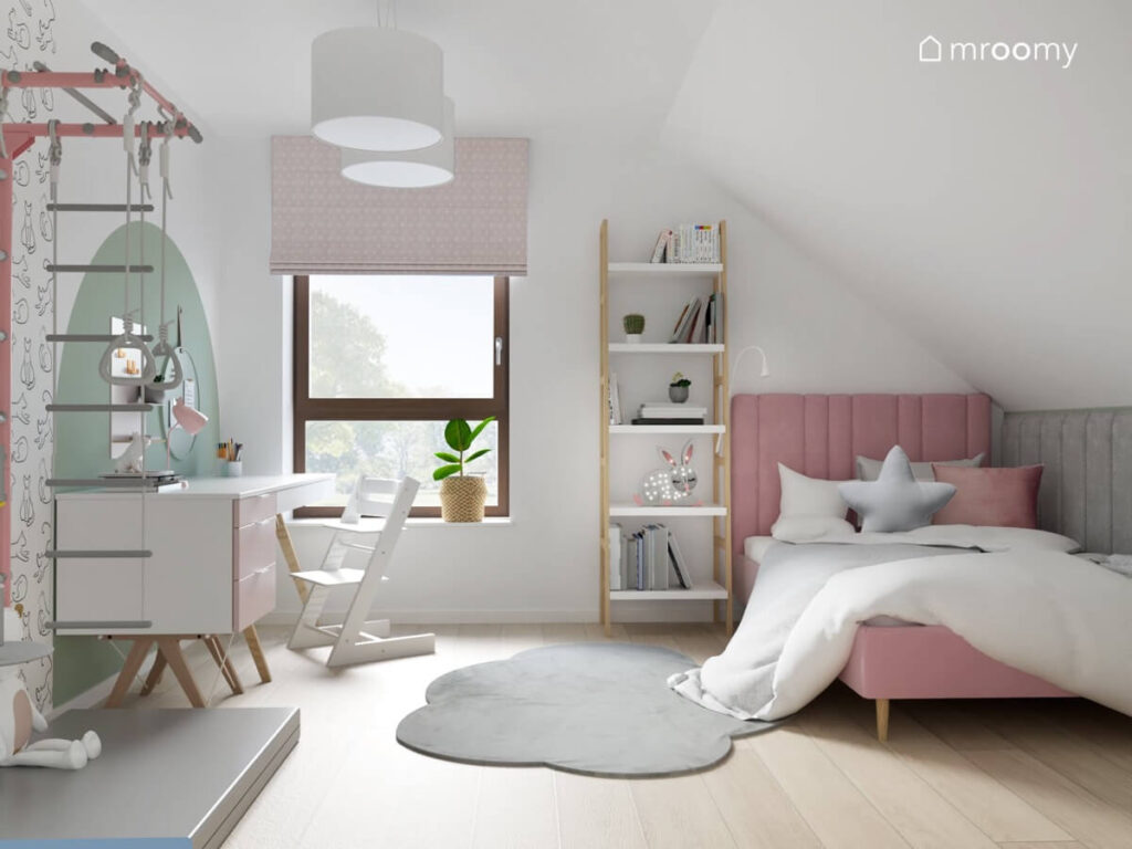 Różowe tapicerowane łóżko regał w kształcie drabinki oraz biało różowe biurko a na podłodze dywanik w kształcie chmurki w pokoju dla dziewczynki