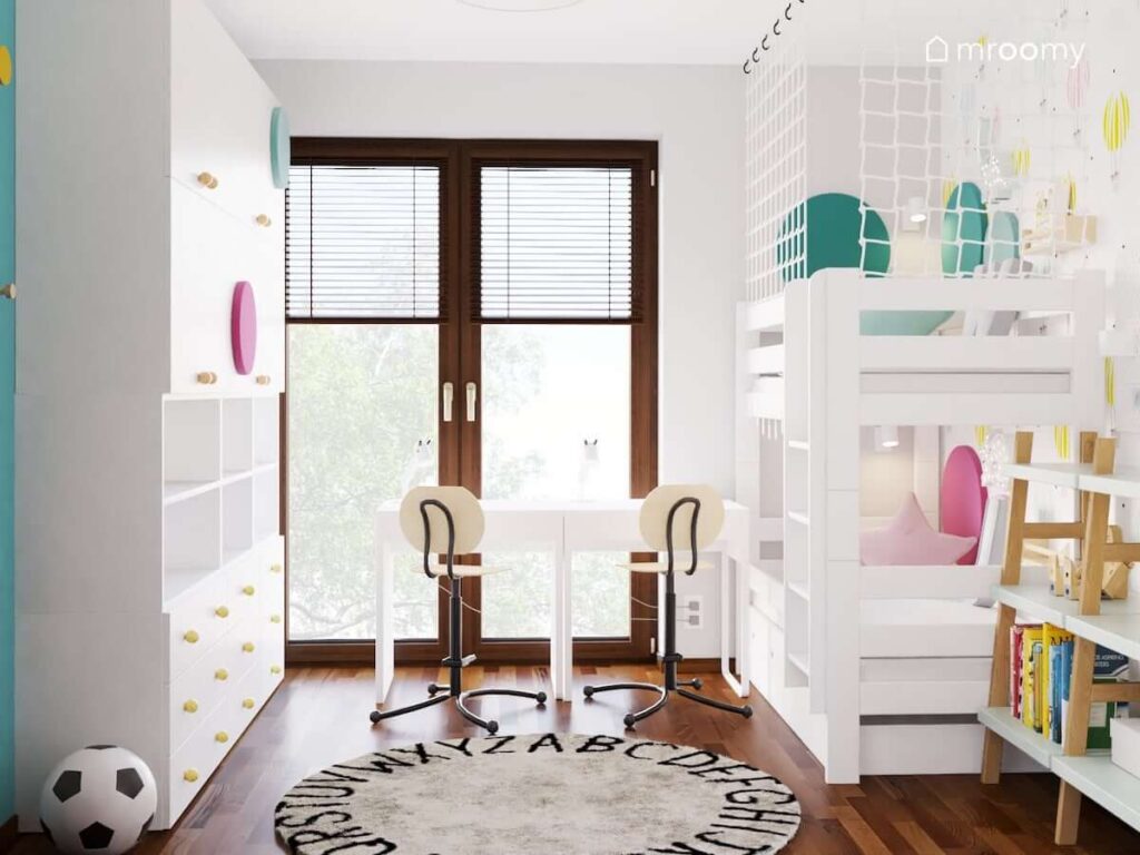 Jasny pokój dla brata i siostry z biała szafą łóżkiem piętrowym biurkami i krzesełkami w podnóżkiem a także z szarym dywanem z alfabetem