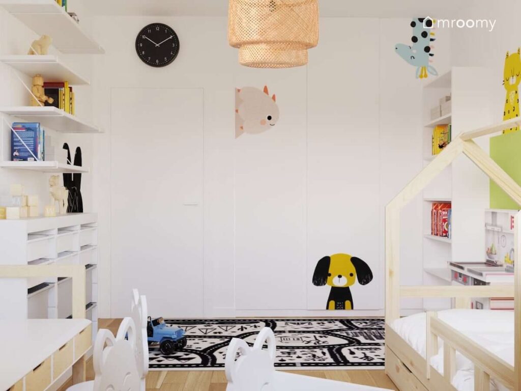 Biały pokój dla rodzeństwa ze ścianami ozdobionymi naklejkami w kształcie zwierząt oraz białymi i drewnianymi meblami