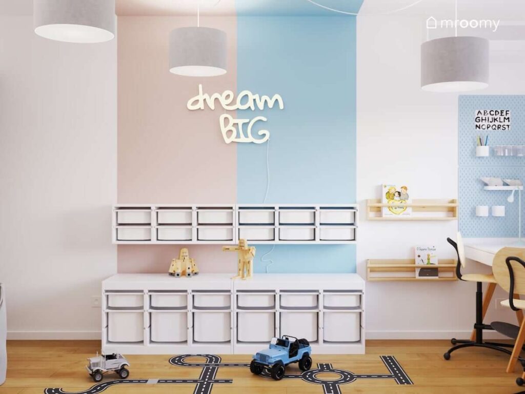 Różowo niebieska ściana w pokoju brata i siostry z regałami z pojemnikami na zabawki drewnianymi półkami ściennymi i ledonem