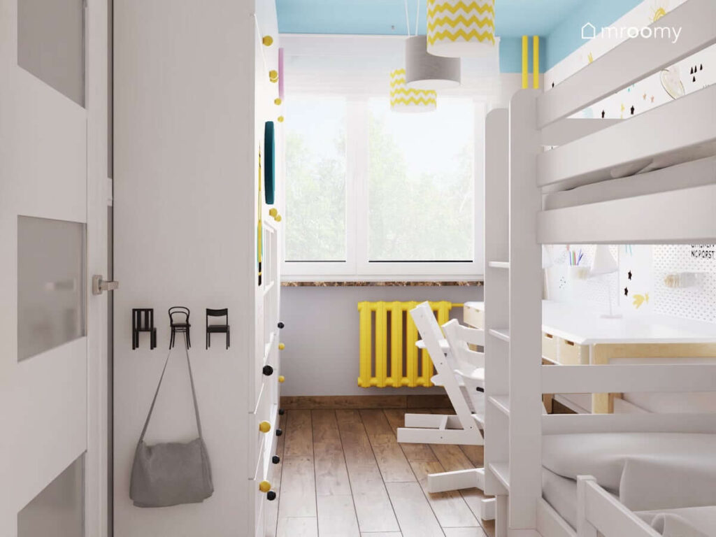 Szaro niebieski pokój dla rodzeństwa z białą szafą łóżkiem piętrowym kaloryferem pomalowanym na żółto oraz wieszakami w kształcie krzesełek