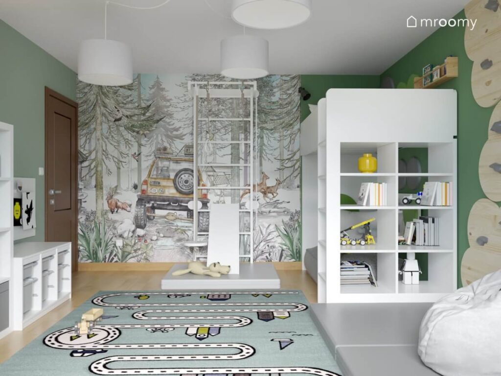 Zielony pokój dla chłopca a w nim łóżko na antresoli drabinka gimnastyczna tapeta z terenówką i dywan z motywem miasta