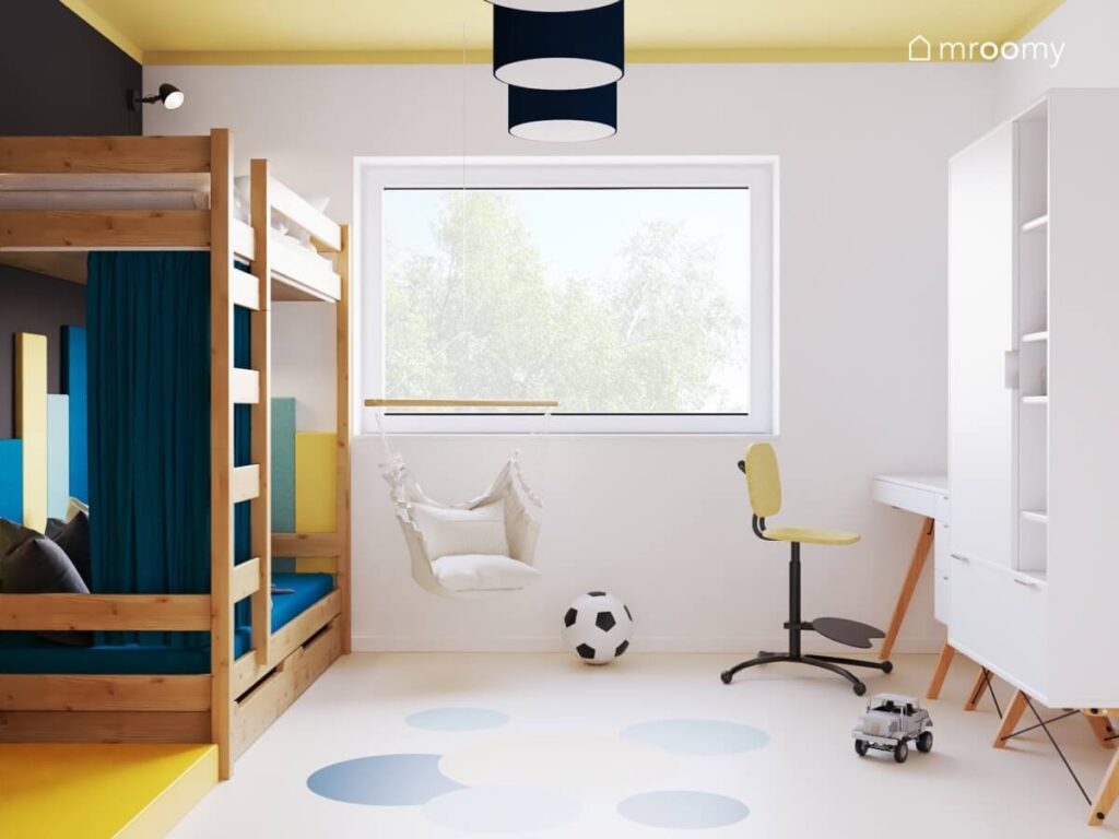 Biało czarny pokój dla chłopca a w nim żółty sufit drewniane łóżko piętrowe fotel wiszący oraz biała szafa i biurko