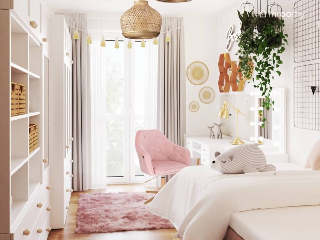 Jasny pokój dla nastolatki a w nim białe meble różowy fotel obrotowy kwietniki i różowy dywan futerkowy a na suficie bambusowe lampy