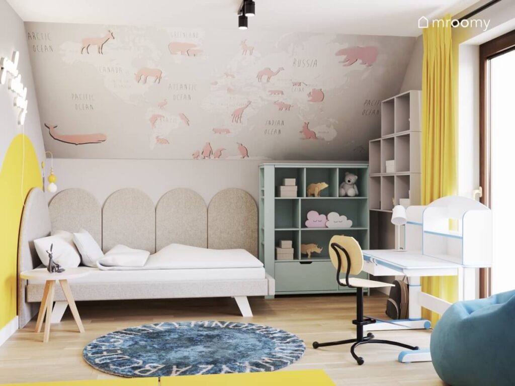 Kolorowy pokój dla dziewczynki z tapicerowanym łóżkiem miętowym regałem dywanem z alfabetem i tapetą w zwierzęta na skosie