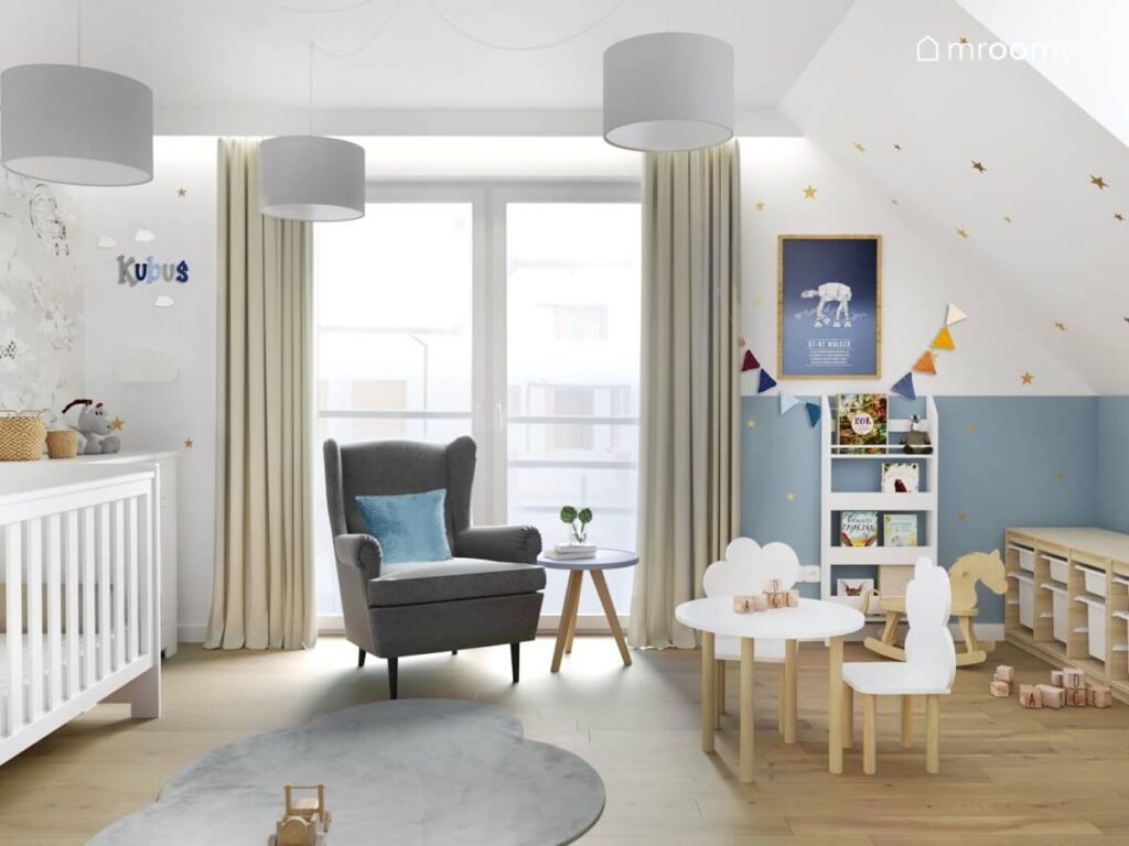 Biało niebieski pokój dla noworodka a w nim szary fotel szary dywanik w kształcie chmurki stolik z krzesełkami z oparciami w kształcie chmurek