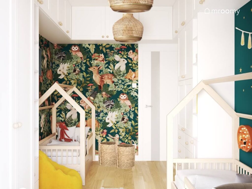 Biało zielony pokój dla dwóch braci a w nim drewniane łóżka domki wiklinowe kosze bambusowe lampy sufitowe i tapeta w zwierzęta leśne