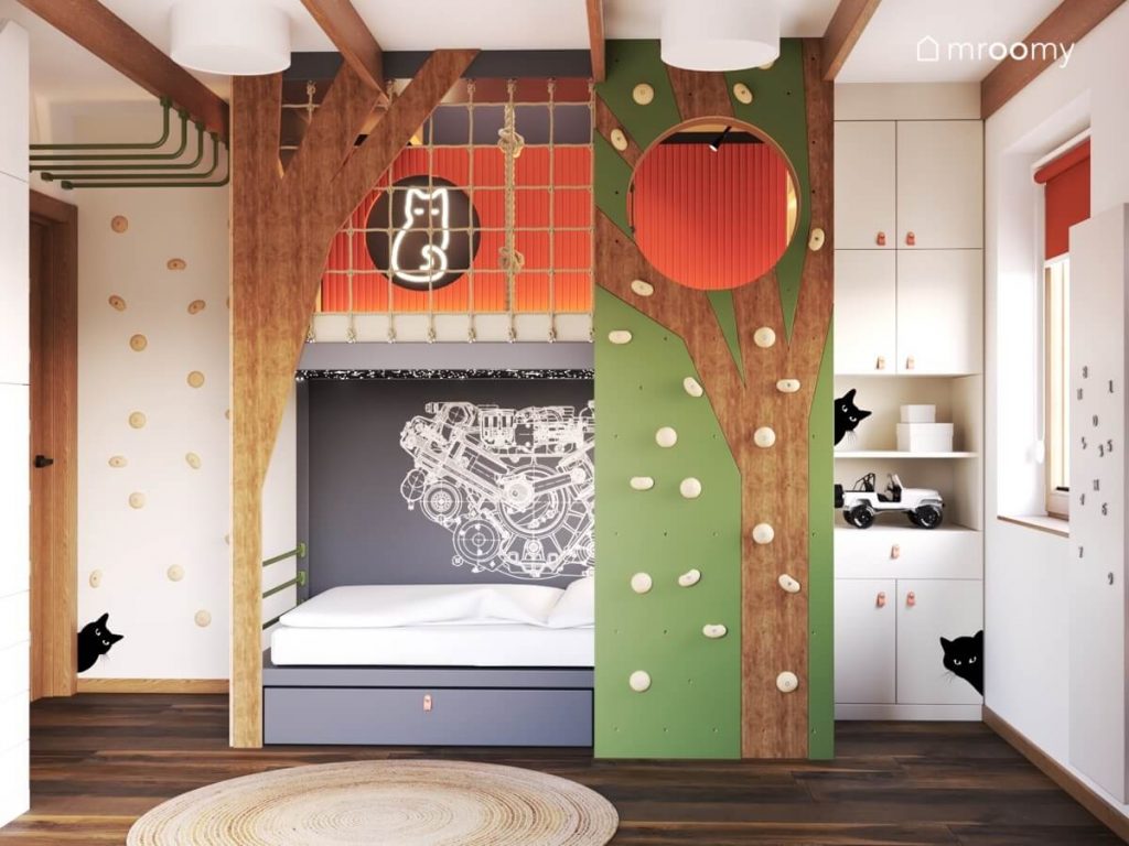 Łóżko z antresolą przypominające formą drzewo a obok panele wspinaczkowe i szafki ze skórzanymi uchwytami w pokoju dla chłopca w wieku szkolnym