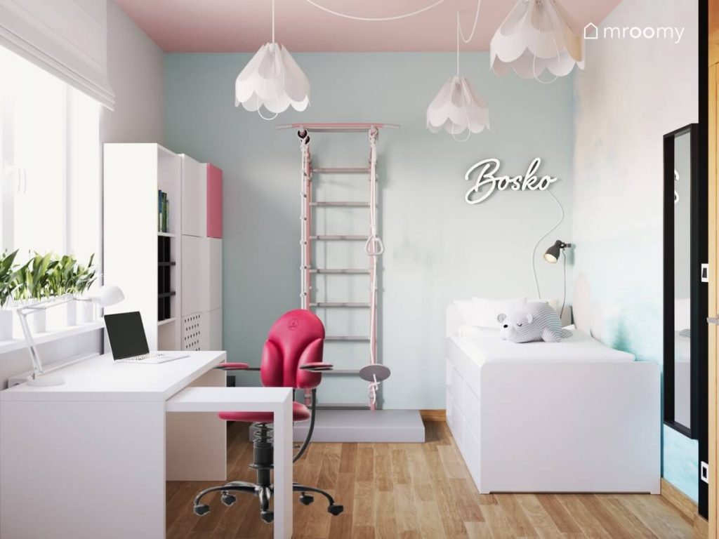 Jasny miętowo szaro biały pokój nastolatki a w nim białe biurko z różowym krzesłem drabinka gimnastyczna białe łóżko a na różowym suficie lampy bezy