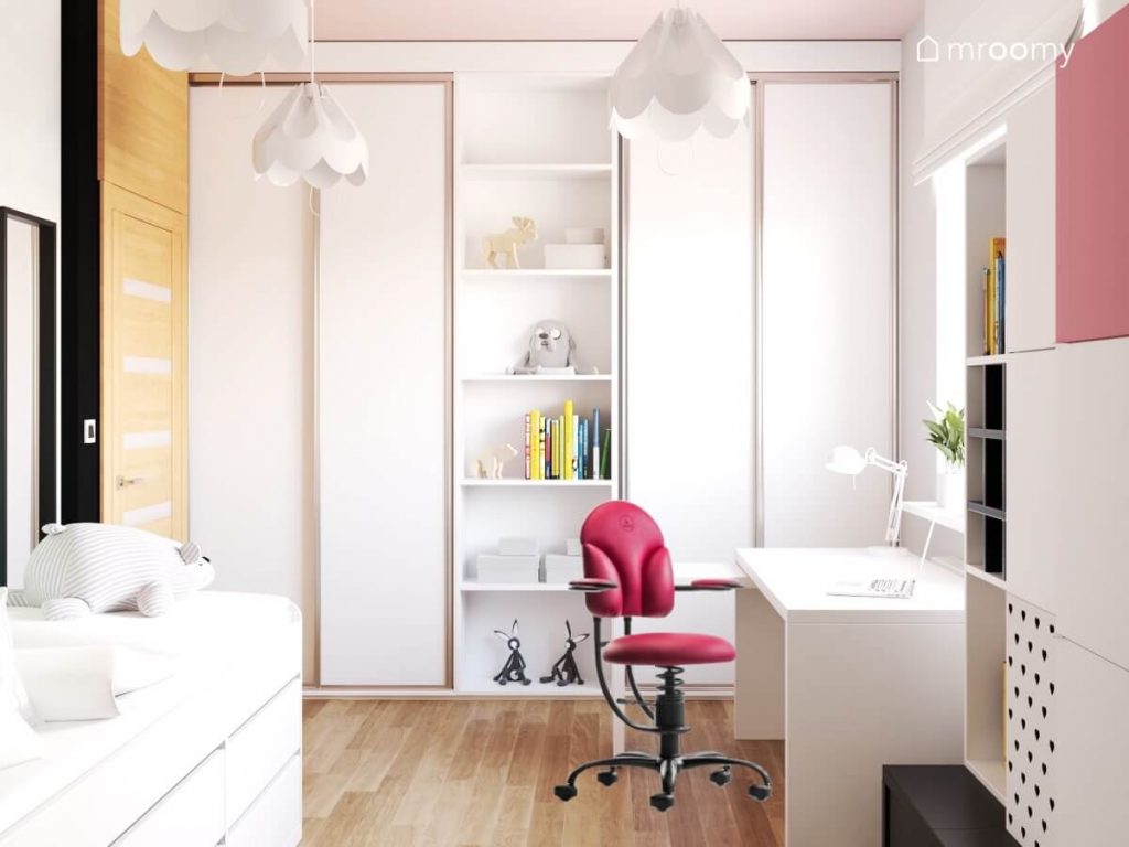 Duże białe szafy i regał oraz białe biurko z różowym krzesłem w jasnym pokoju nastolatki