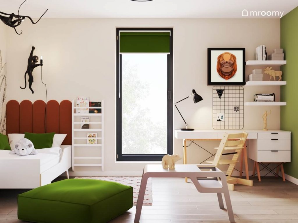 Beżowo zielony pokój dla dziewczynki a w nim białe łóżko uzupełnione rdzawymi panelami ściennymi biblioteczka ścienna zielona pufa oraz biurko z organizerem i półkami