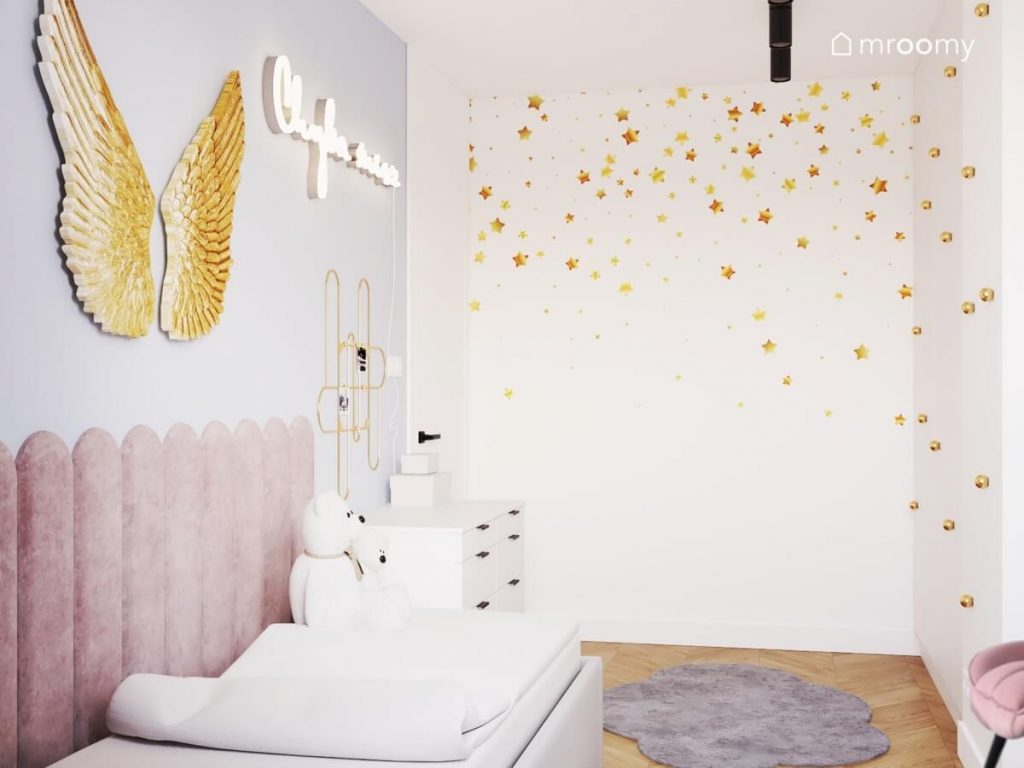 Niebiesko biały pokój dla dziewczynki ze ścianami ozdobionymi tapetą w złote gwiazdki oraz dekoracją w kształcie skrzydeł i ledonem w kształcie napisu
