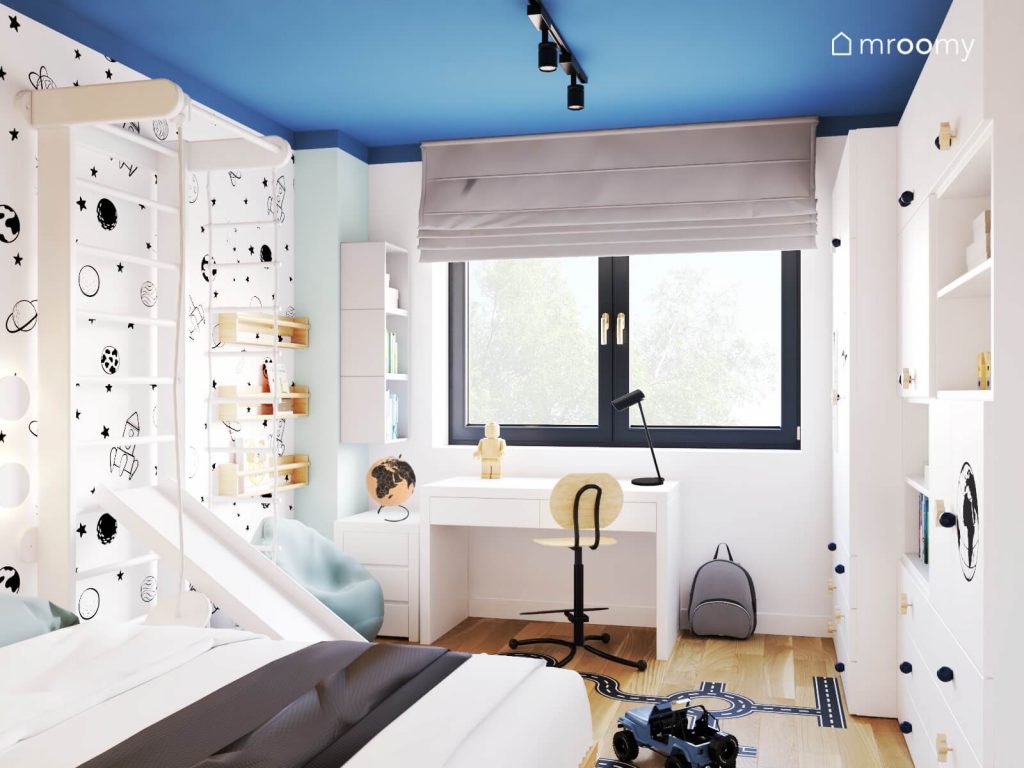 Biało niebieski pokój sześciolatka a w nim białe meble drabinka gimnastyczna ze zjeżdżalnią i naklejka w kształcie jezdni na podłodze