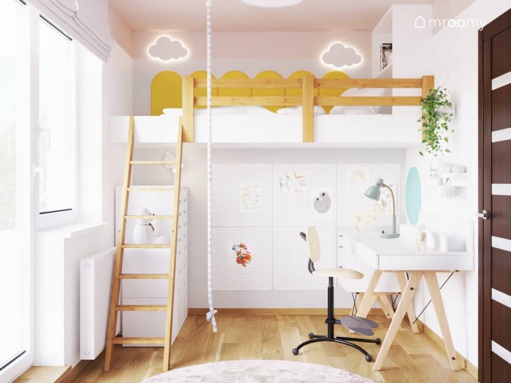 Biało różowy pokój dla dziewczynki a w nim łóżko na antresoli ozdobione dwoma lampkami w kształcie chmurek i żółtymi panelami ściennymi a pod nim biurko i organizery ścienne