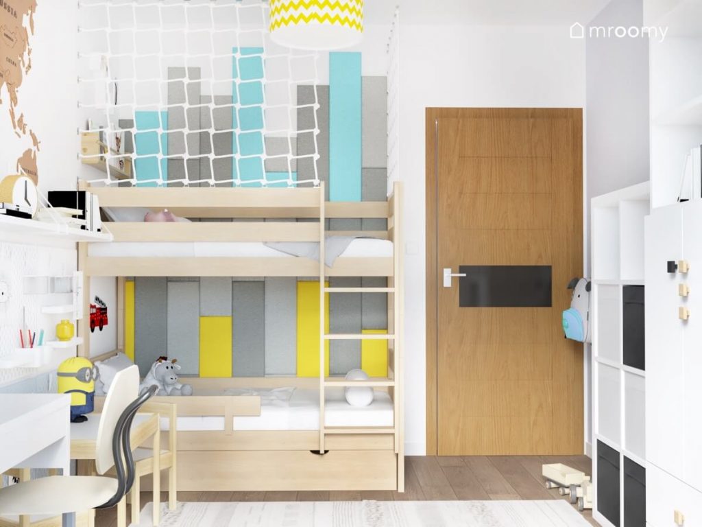 Drewniane łóżko piętrowe w pokoju dla rodzeństwa uzupełnione prostokątnymi panelami w kolorze szarym niebieskim i żółtym