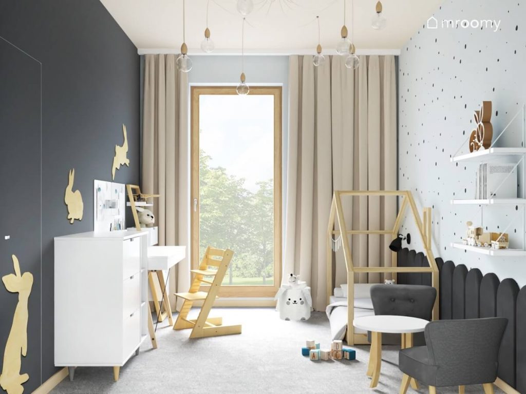 Szaro błękitno beżowy pokój dla małego chłopca a w nim białe i drewniane meble sklejkowe króliki na ścianach oraz żyrandol z wieloma żarówkami