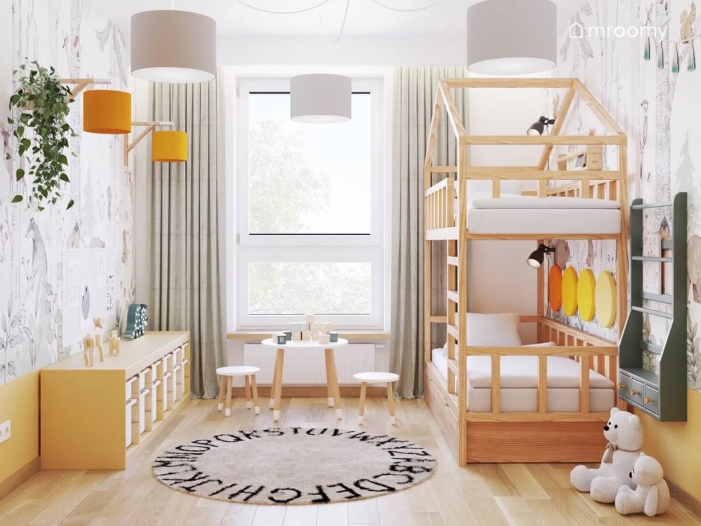 Przytulny pokój dwóch małych chłopców a w nim piętrowe łóżko w kształcie domku dywan z alfabetem drewniany regał z pojemnikami oraz stoliczek z taborecikami