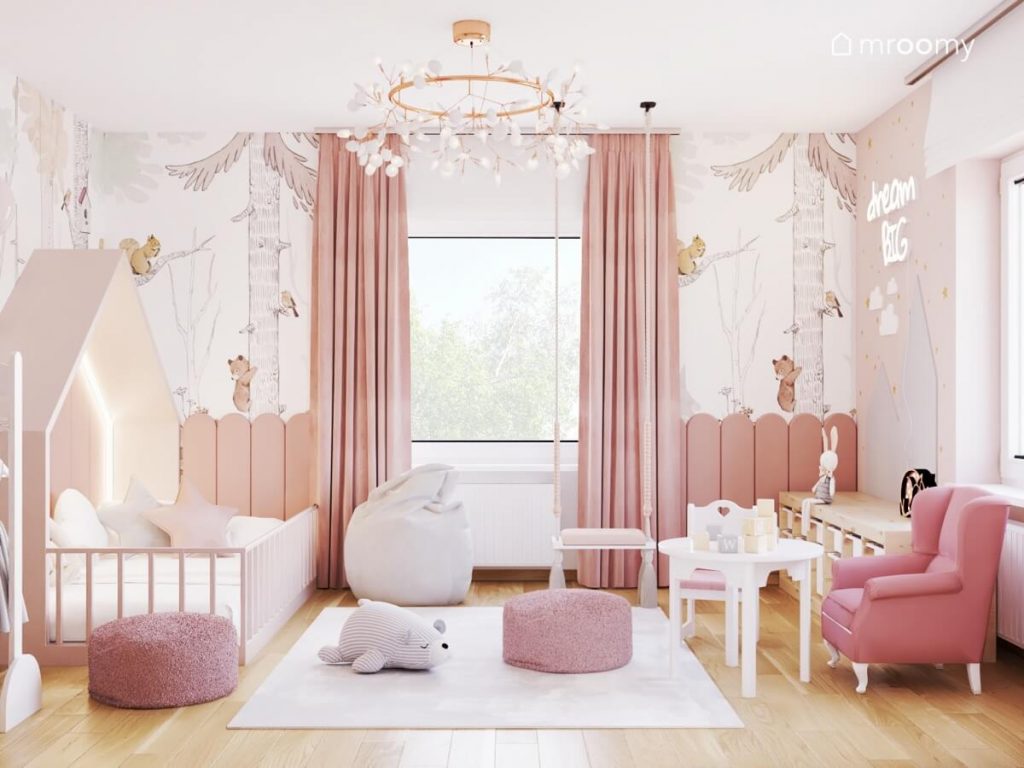 Jasny pokój dla małej dziewczynki a w nim białe i drewniane meble różowe dodatki i leśna tapeta