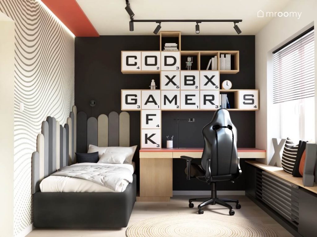 Młodzieżowy pokój dla nastolatka utrzymany w stonowanych kolorach z łóżkiem uzupełnionym szarymi panelami ściennymi oraz biurkiem i szafkami z gamingowymi motywami