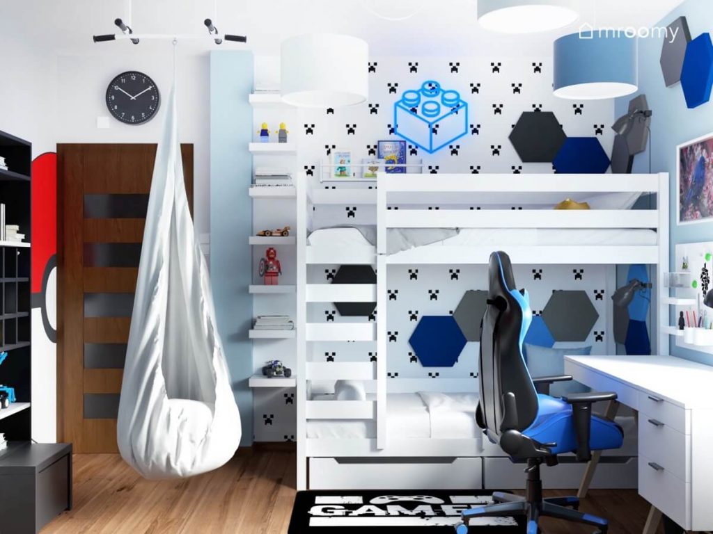Białe łóżko piętrowe szary fotel kokon a na ścianie tapeta z Minecrafta ledon w kształcie klocka i sześciokątne panele w pokoju dla chłopca