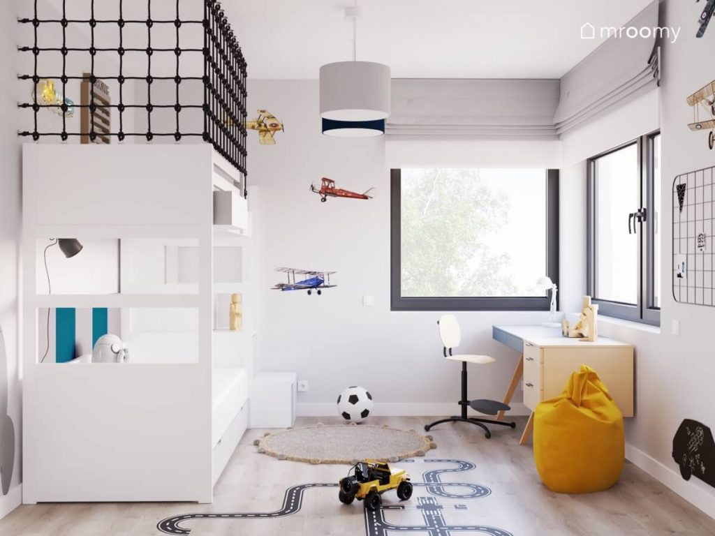 Jasny pokój dla chłopca z białą antresolą naklejkami ściennymi w kształcie samolotów oraz naklejką jezdnią na podłodze