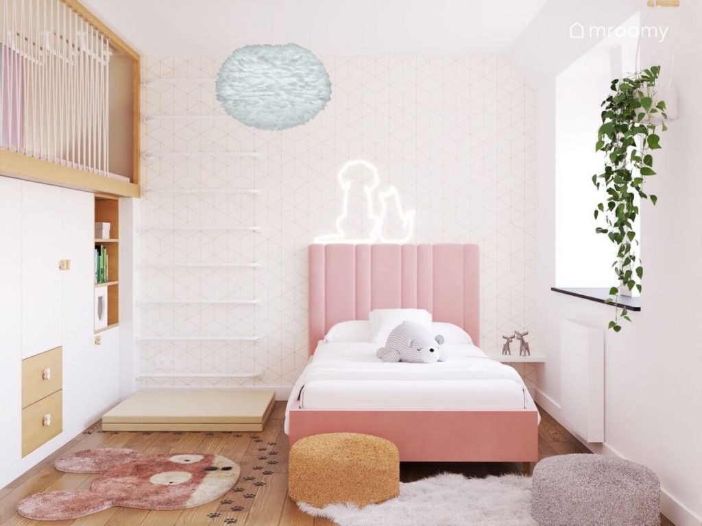 Strefa spania w pokoju kilkulatki z różowym tapicerowanym łóżkiem błękitną lampą z ptasich piór i ledon w kształcie psa i kota