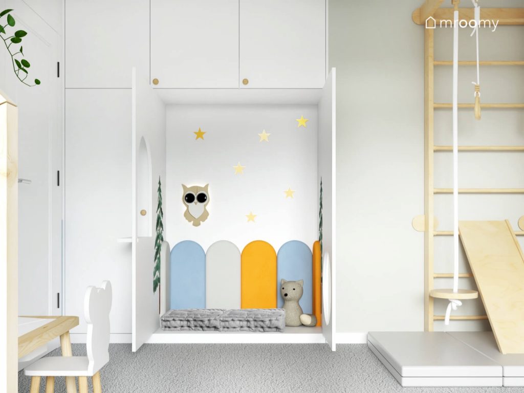 Ukryty przytulny kącik dla małego chłopca uzupełniony kolorowymi panelami gwiazdkami oraz lampką w kształcie sowy
