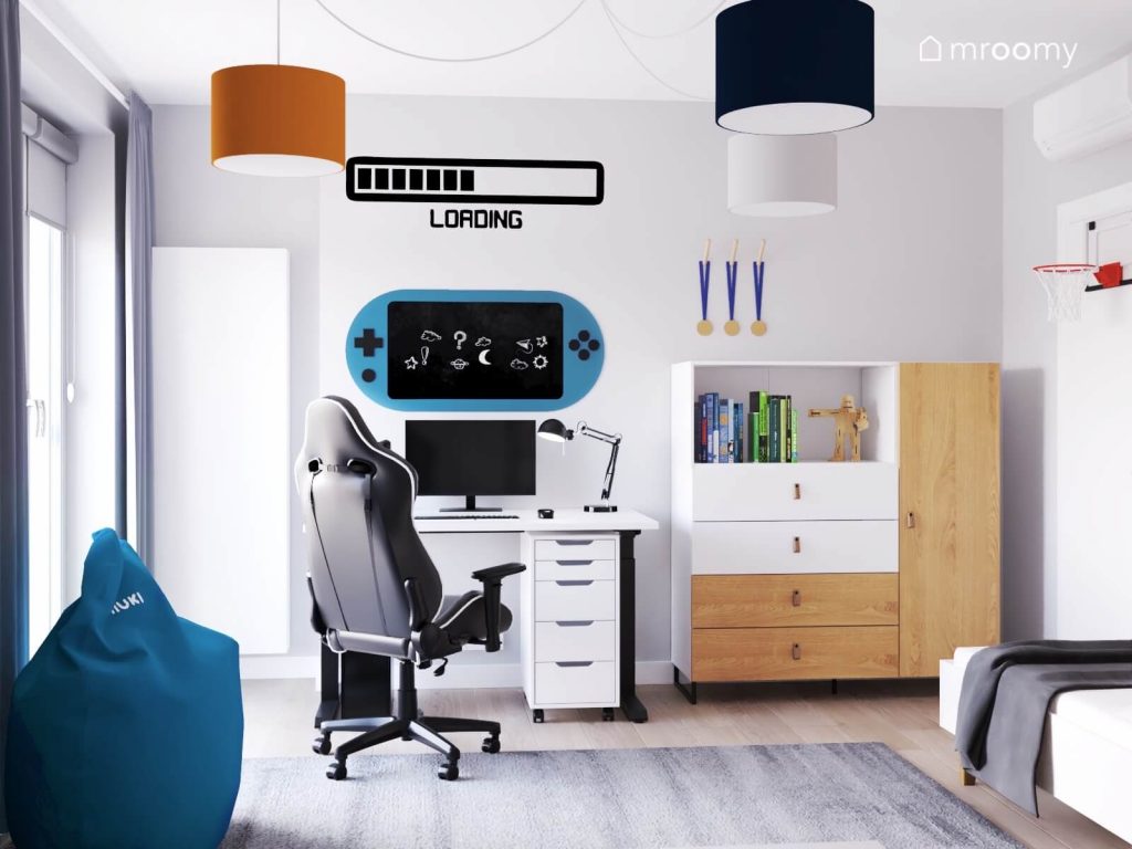 Jasny pokój chłopca z biało drewnianymi meblami oraz gamingowymi naklejkami na ścianach