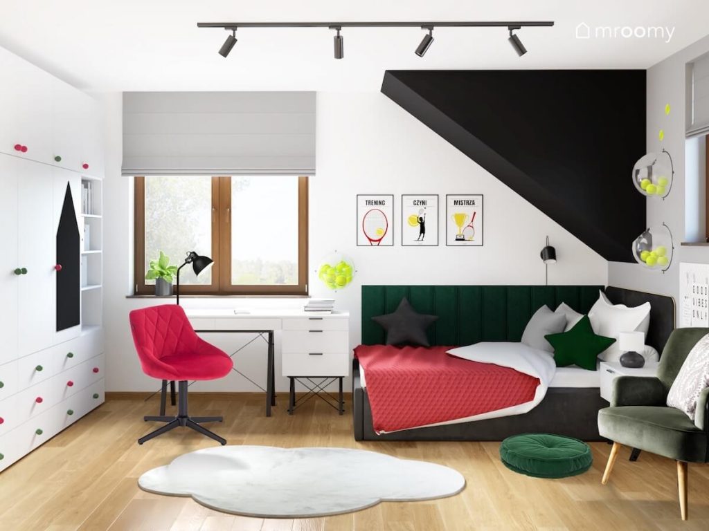 Poddaszowy pokój dla dziewczynki a w nim biało szaro czarne ściany białe meble ciemnoszare łóżko oraz tenisowe akcesoria i czerwone i zielone dodatki
