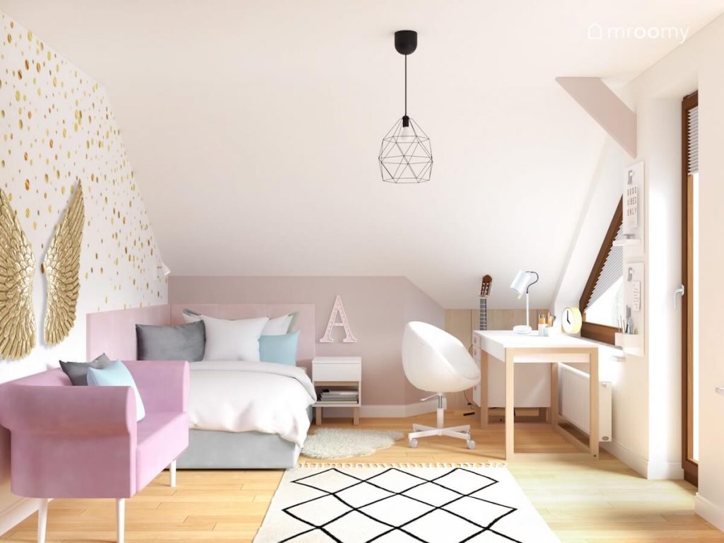 Biało szary poddaszowy pokój dziewczynki a w nim biało drewniane biurko z białym krzesłem szare łóżko różowa sofa wzorzysty dywan i lampa sufitowa z geometrycznym kloszem