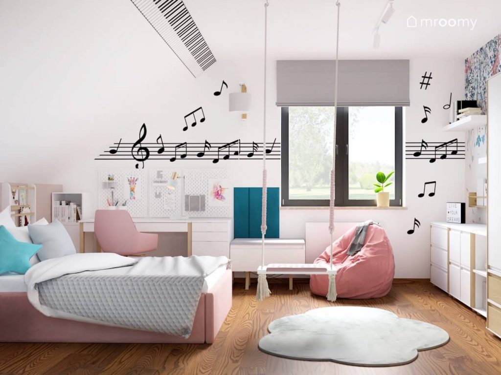 Biały pokój dla miłośniczki muzyki a w nim białe i różowe meble huśtawka wisząca dywanik w kształcie chmurki i naklejki ścienne z nutami