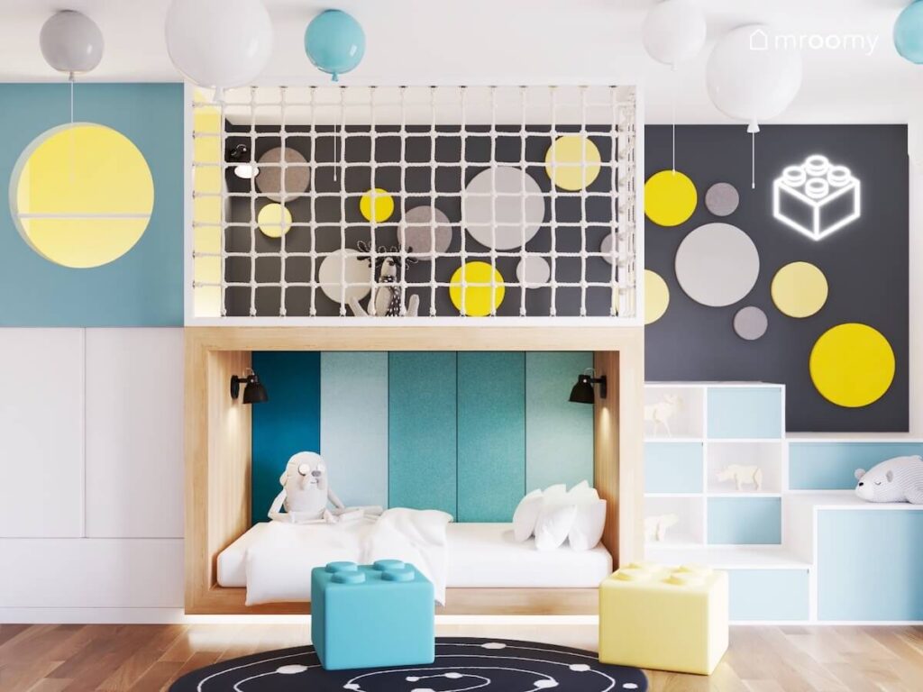 Drewniana antresola z miejscem do zabawy i łóżkiem pod spodem a na suficie lampy balony w pokoju dla chłopca