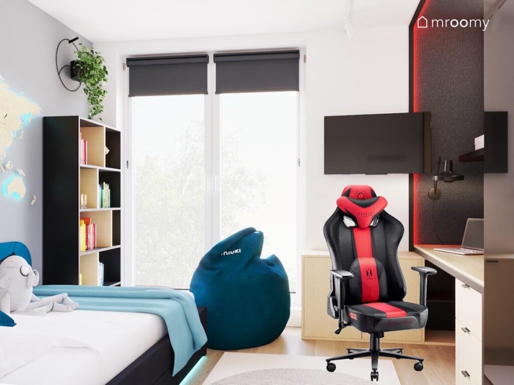 Biało szary pokój dla chłopca a w nim czarno drewniane meble fotel gamingowy telewizor oraz ciemnoniebieska pufa