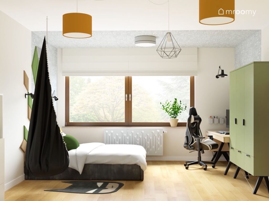 Jasny pokój dla chłopca a w nim fotel kokon tapicerowane łóżko zielona szafa i drewniane biurko a u sufitu lampy z różnymi kloszami
