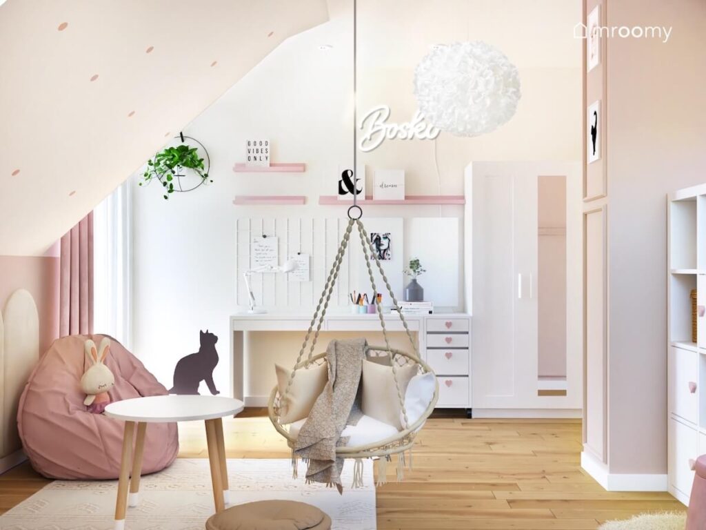 Jasny poddaszowy pokój dla dziewczynki a w nim białe meble różowy worek do siedzenia fotel wiszący oraz lampa sufitowa w ozdobnym kloszu