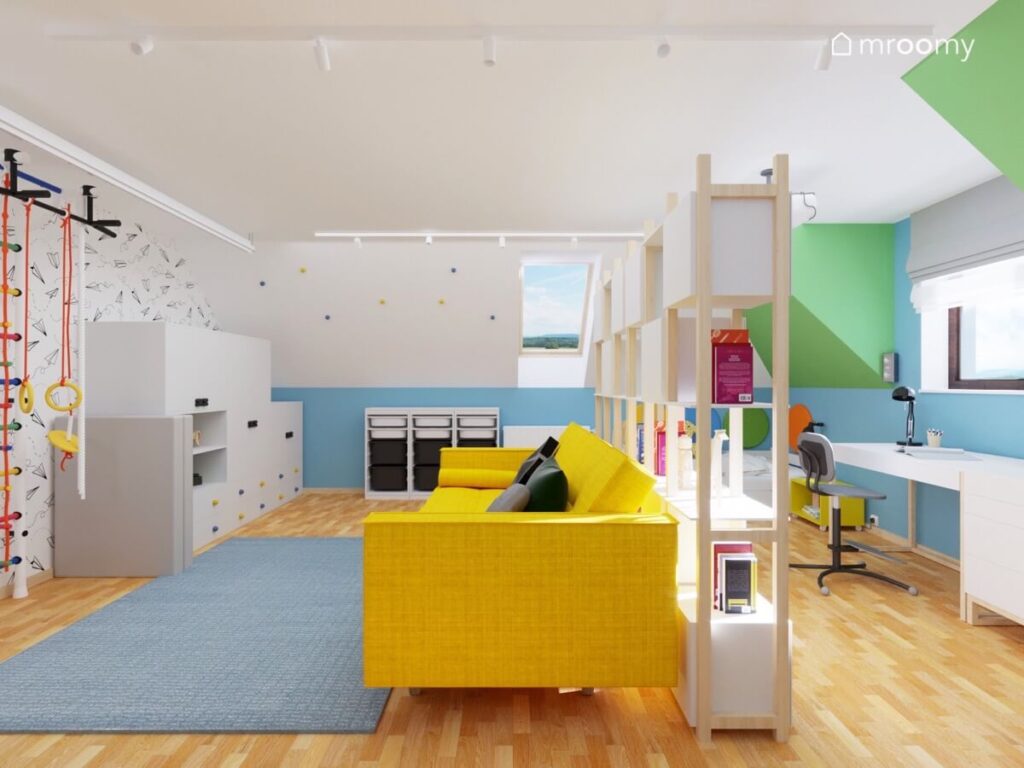 Biało niebiesko zielony poddaszowy pokój dla chłopca a w nim jasne meble oraz żółta sofa i duży niebieski dywan