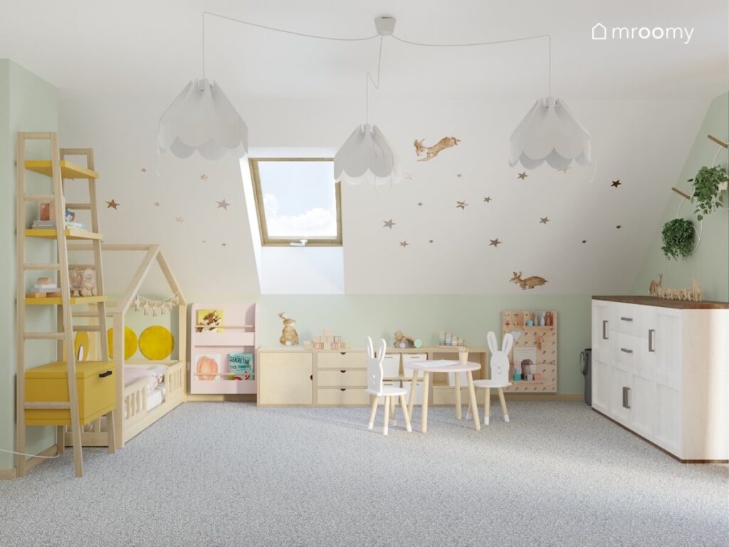 Poddaszowy pokój dla rocznej dziewczynki a w nim drewniane meble lampy bezy a na skosie gwiazdki i króliki