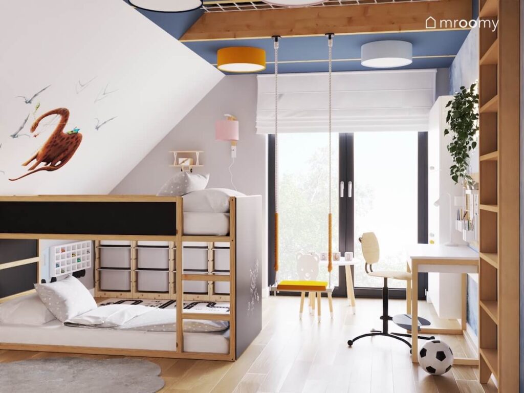 Biało szaro niebieski poddaszowy pokój dla małego rodzeństwa a w nim łóżko piętrowe z powierzchniami kredowymi huśtawka wisząca oraz plafony na suficie