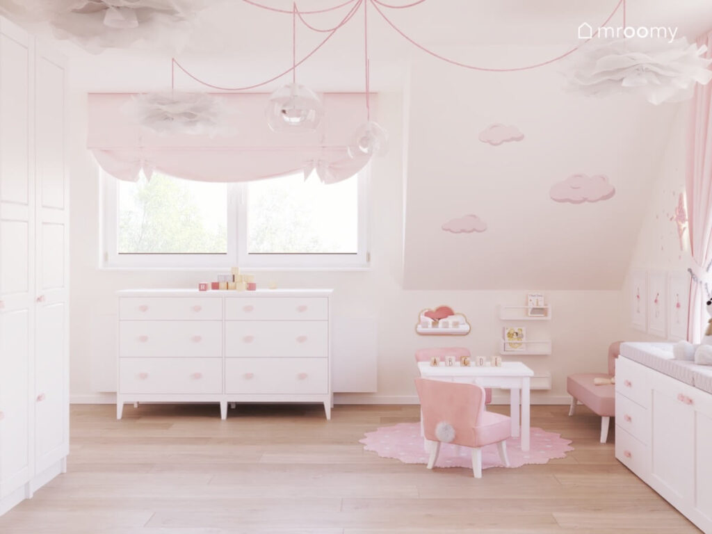 Poddaszowy pokój dziewczynki w wieku przedszkolnym a w nim białe meble chmurki na skosie oraz krzesełko z króliczą kitą